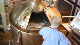 man stirring beer in vat