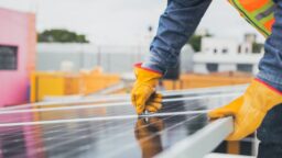 Electrician placing solar panels on a roof to increase energy efficiency